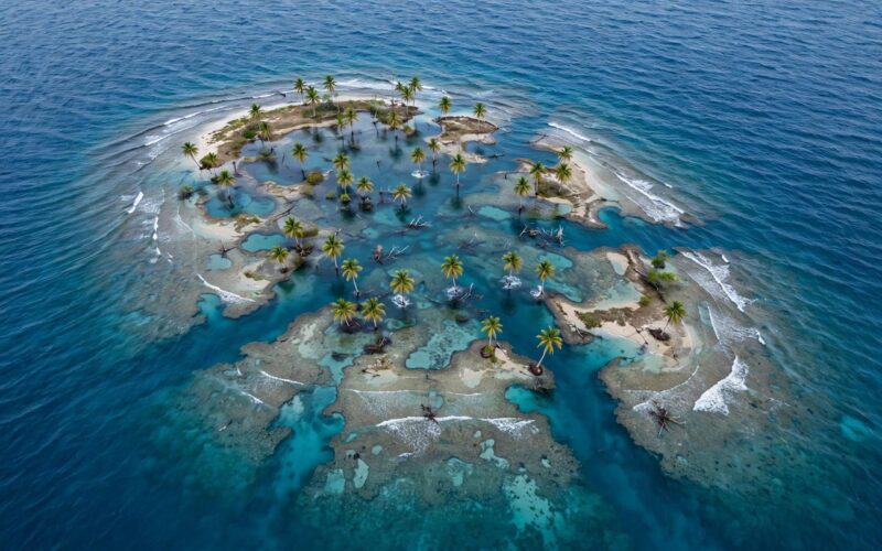 Small tropical island surrounded by rising sea water