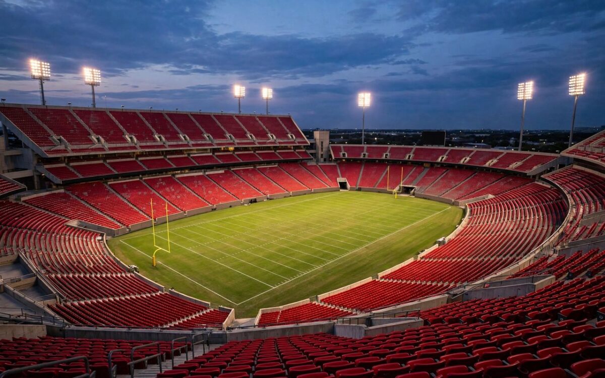 American football stadium at dusk with glowing floodlights