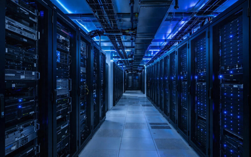 A modern data center corridor with illuminated server racks.