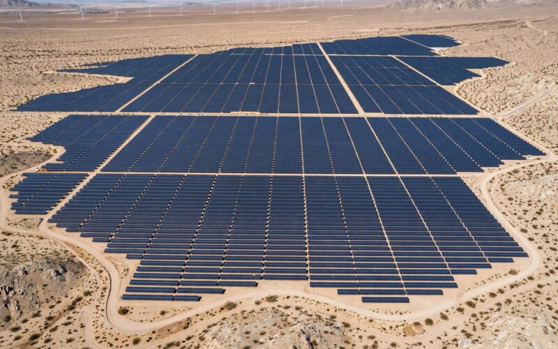 Solar panels and wind turbines stretch across the desert at the Khavda renewable energy park.