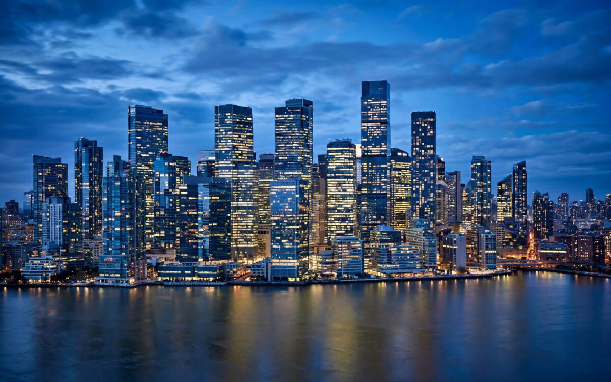 Glass office towers of a financial district at blue hour.