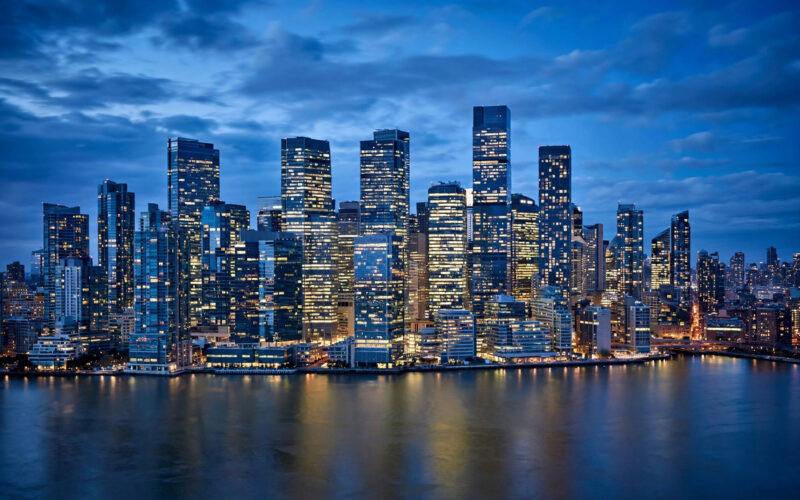 Glass office towers of a financial district at blue hour.