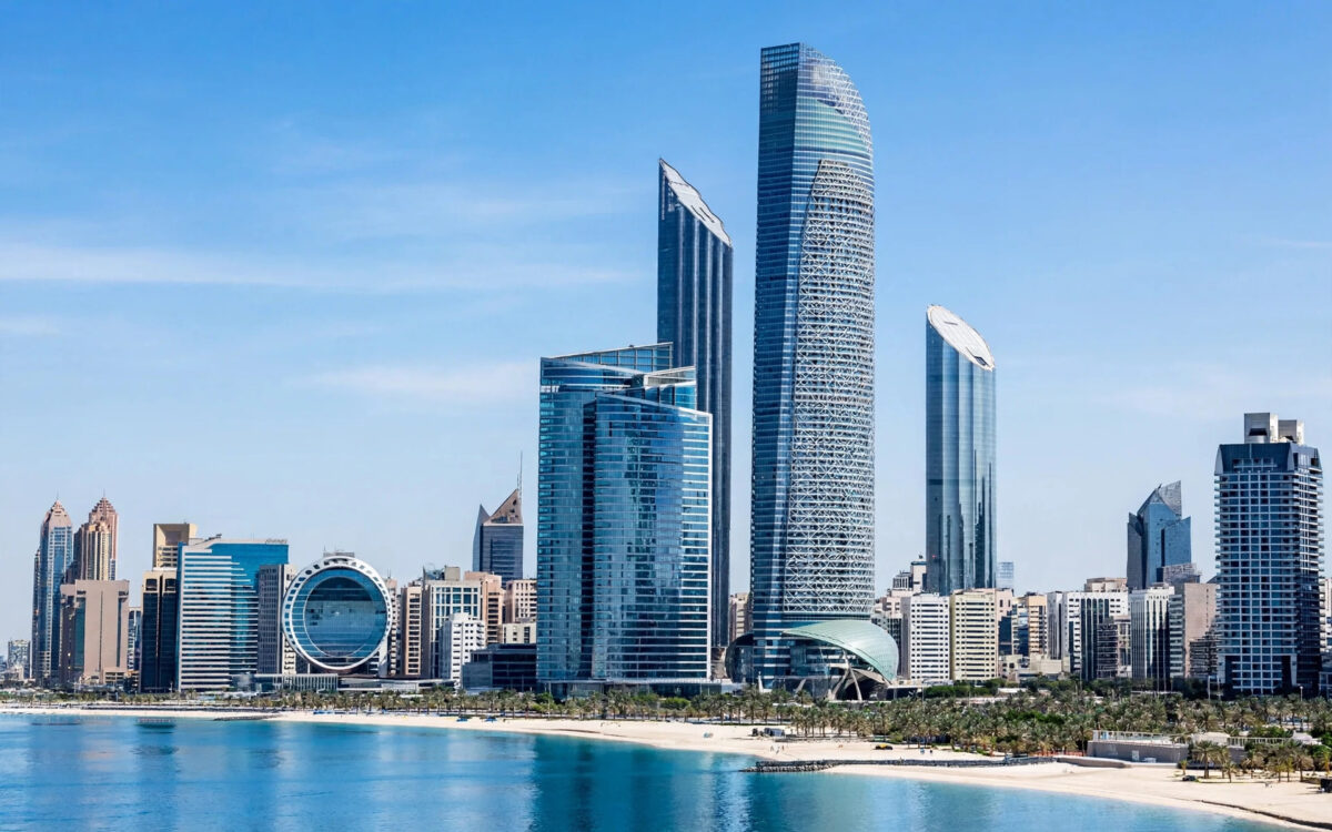 The Abu Dhabi skyline under a clear blue sky.