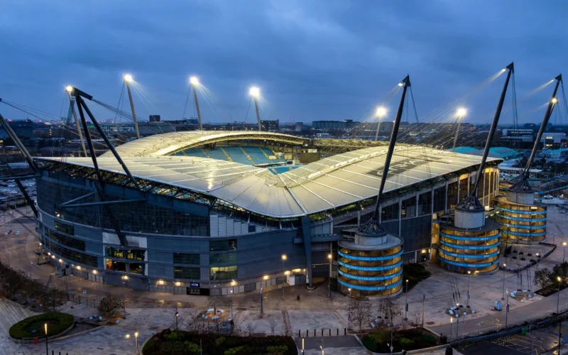 Etihad Stadium at dusk with floodlights