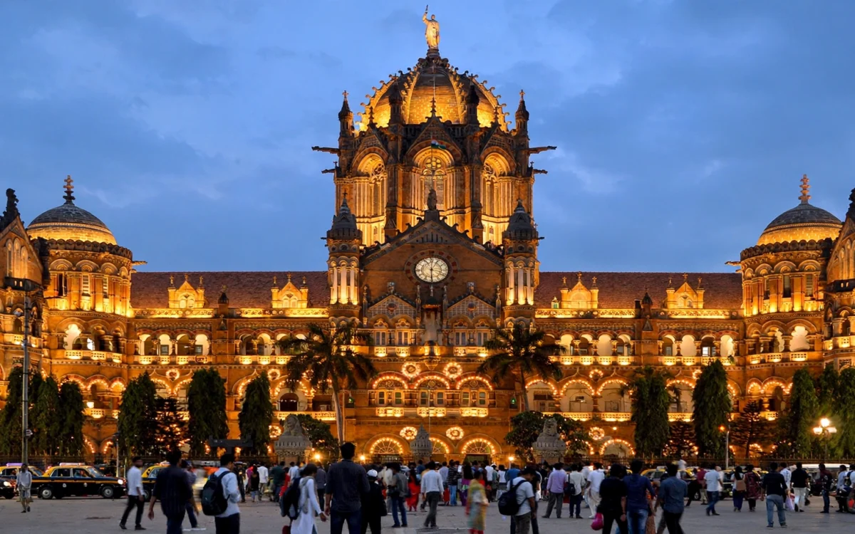 Mumbai's historic CSMT railway station illuminated at dusk.