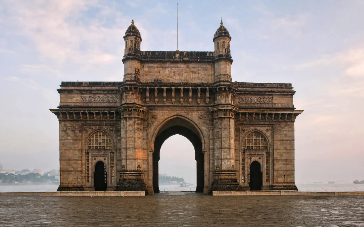 Gateway of India monument in Mumbai at dawn with the empty waterfront plaza in front.