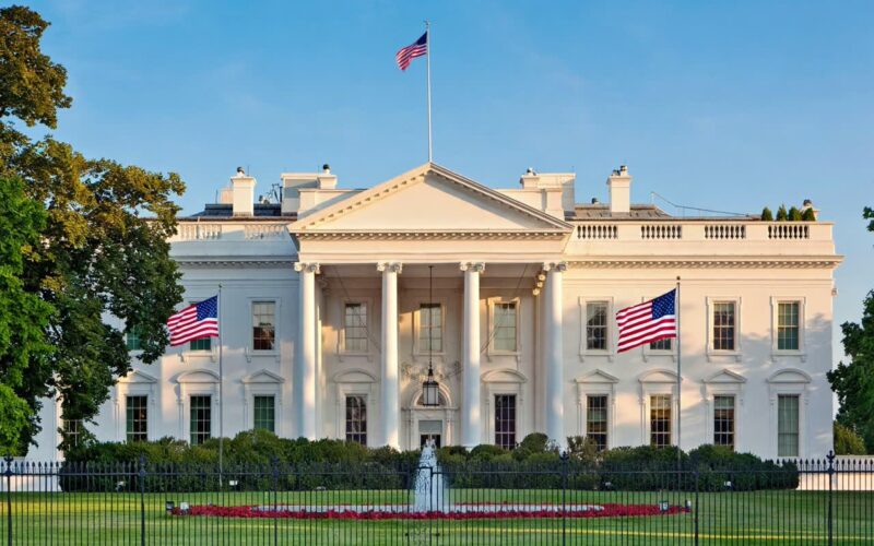 White House exterior with flags on a clear day